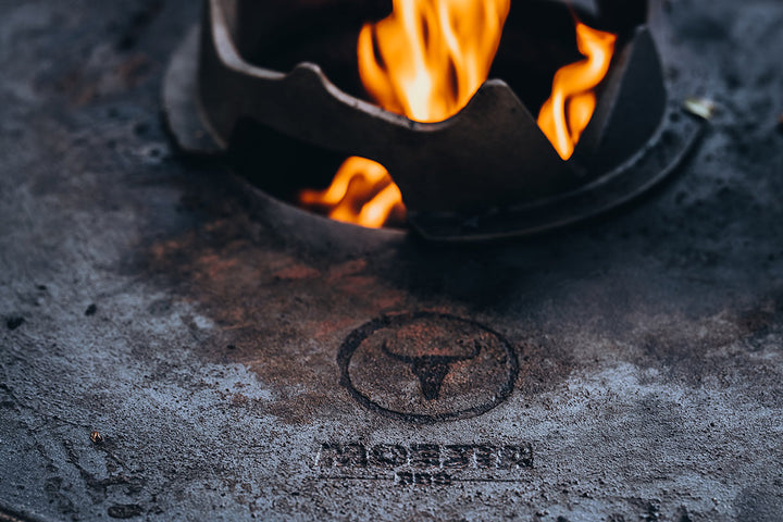 Nahaufnahme der gusseisernen MOESTA BBQ Disk mit Feuer in der Mitte