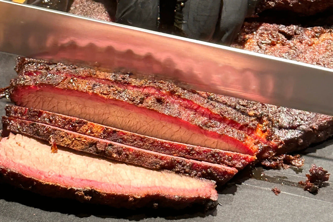 Brisket wird quer zur Faser aufgeschnitten, Scheiben mit dunkler Bark und rosa Rauchring