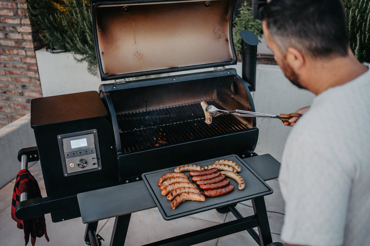 Würstchen und Grillzange am geöffneten MOESTA SHERIFF – ein einfacher Einstieg ins Pelletgrillen