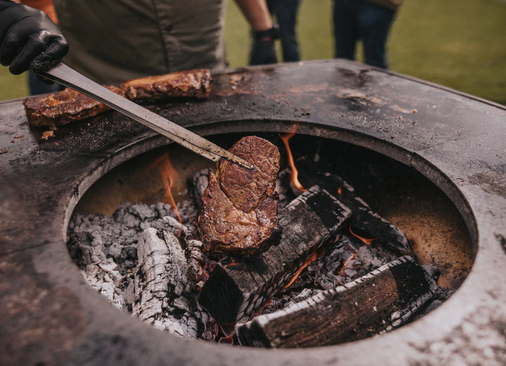 Steak mit kräftiger Kruste auf der Lavasteinplatte des MOESTA ONE, gehalten mit der SIMPLE Zange