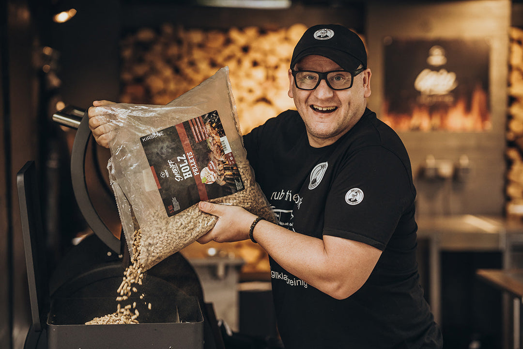 Grillpellets werden aus einem Beutel in den Pelletbehälter des Sheriff gefüllt