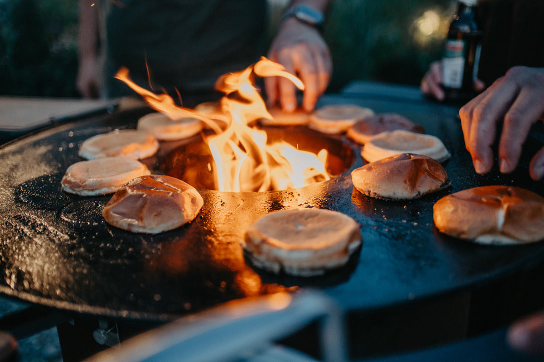 Burgerbrötchen rund um das offene Feuer auf der BBQ Disk