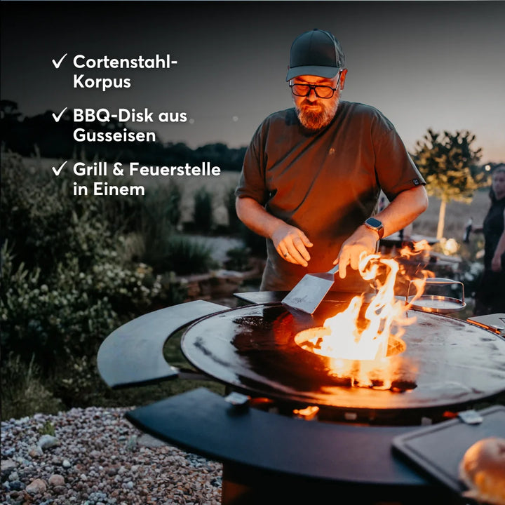 BANDIT 2.0 mit Gusseisen-Feuerplatte und offenem Feuer beim Grillen.