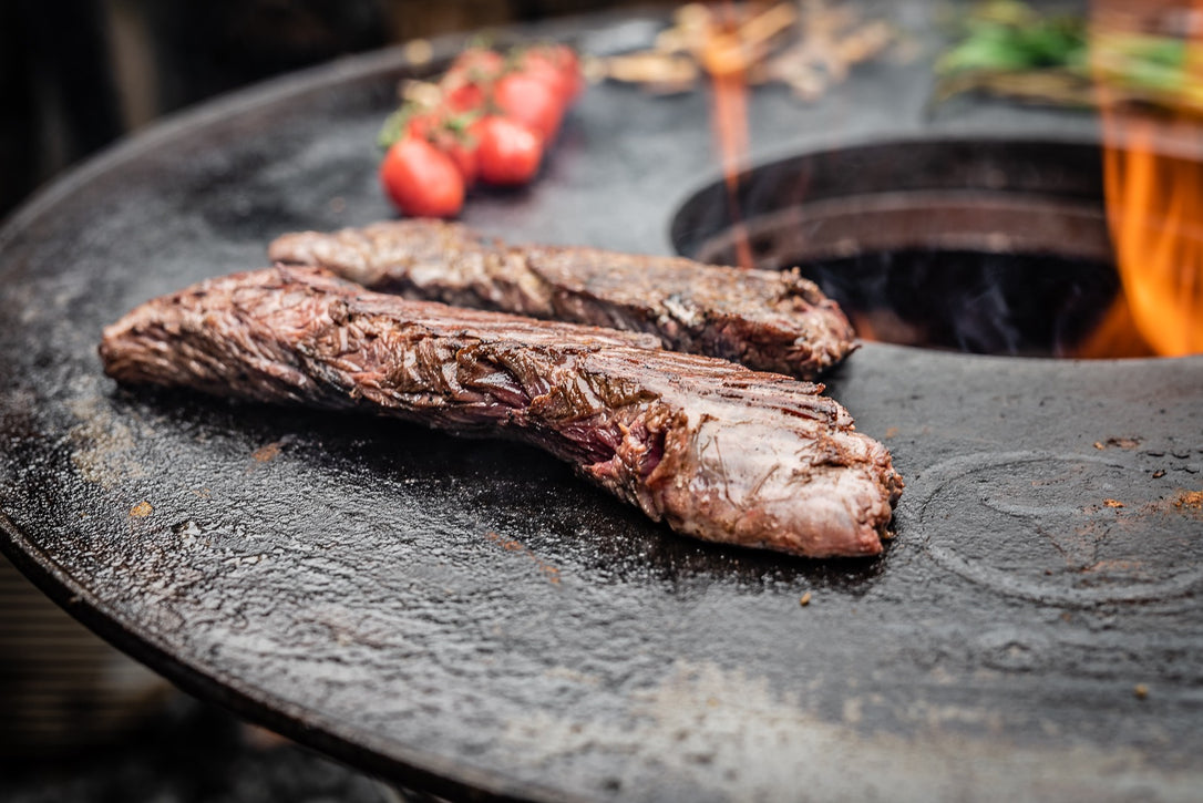 Steak brät auf der gusseisernen Barbecue-Disc.