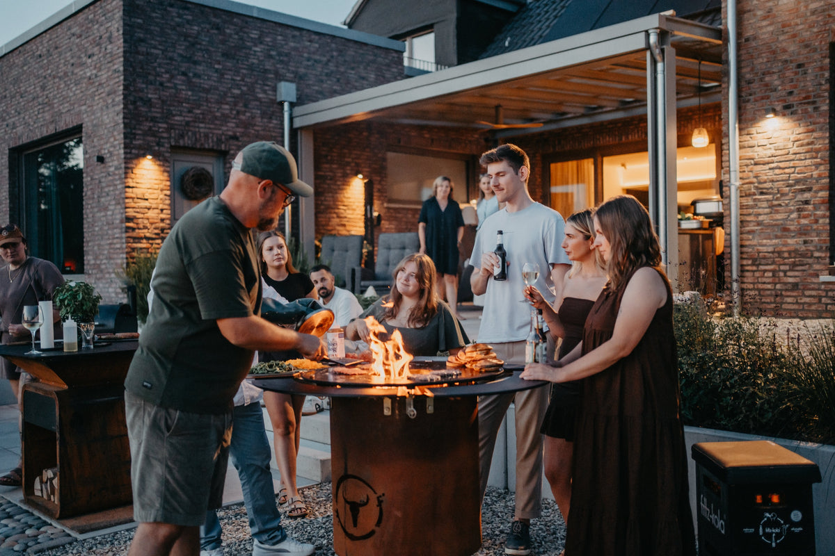 Grillabend auf der Terrasse am MOESTA BANDIT mit offenem Feuer und Freunden in der Abenddämmerung