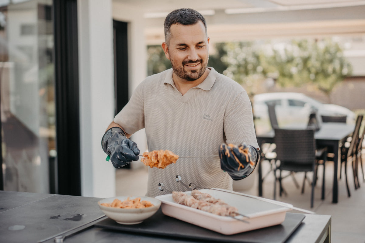 HEATPRO BBQ gloves being used to carve grilled ribs